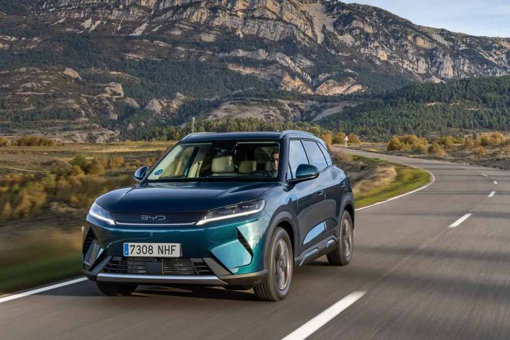 {"fr":"SUV BYD roulant sur une route de montagne panoramique avec ciel dégagé.","nl":"BYD SUV rijdt op pittoreske bergweg met heldere hemel."}