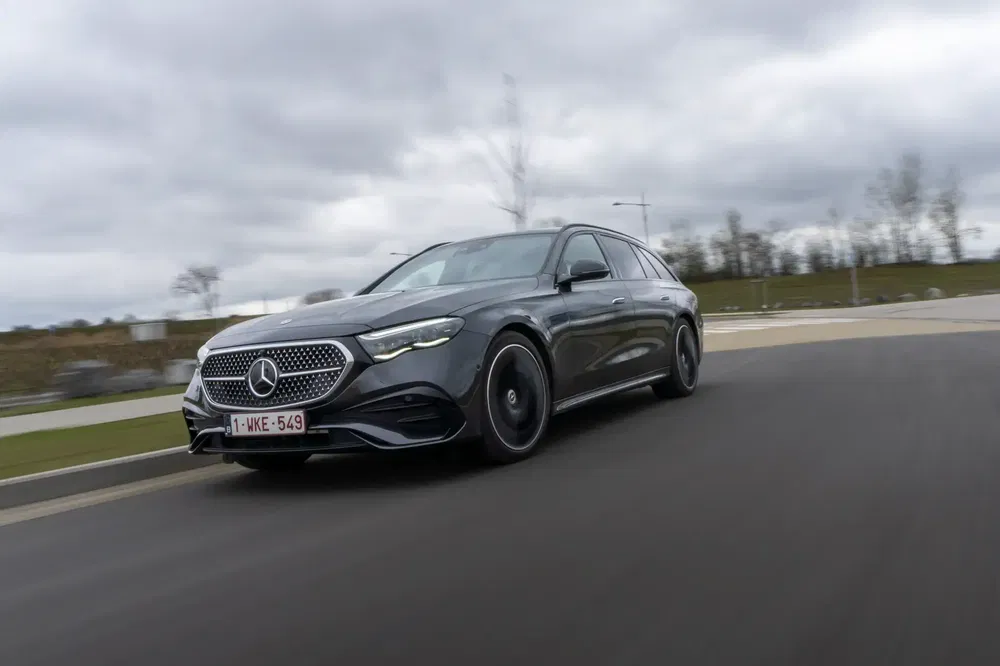 Mercedes-Benz en mouvement sur une route, ciel nuageux en arrière-plan.