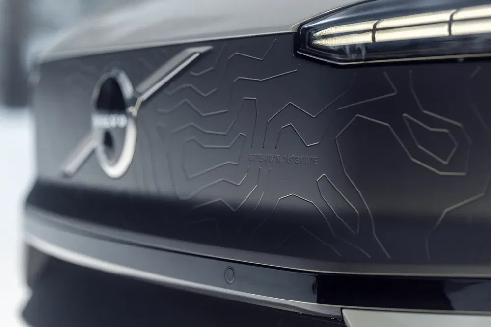 Gros plan du logo Volvo sur une carrosserie noire avec motifs, design moderne.