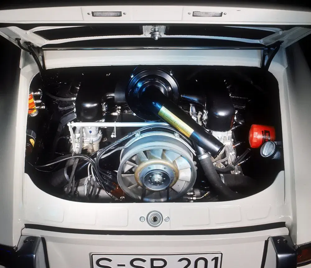 Klassieke Porsche 911 motor, motorruimte open, zichtbare technische details.