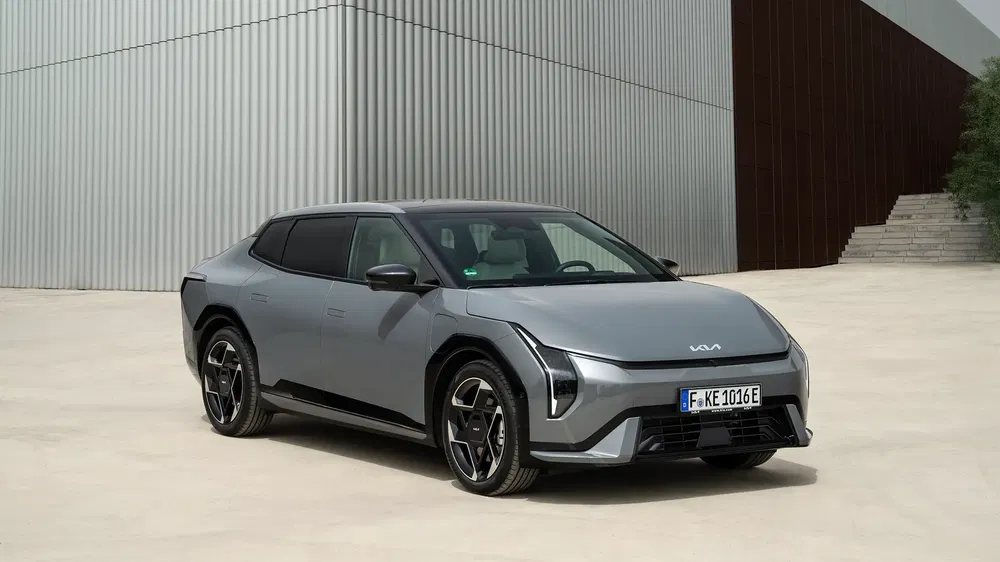 Grijze Kia EV6 geparkeerd voor een modern gebouw, futuristisch en stijlvol ontwerp.