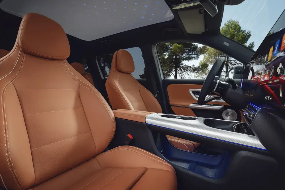 Intérieur de voiture de luxe avec sièges en cuir marron et toit avec éclairage étoilé.