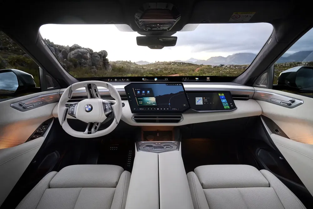 Intérieur moderne de BMW avec tableau de bord numérique entouré de paysages naturels.