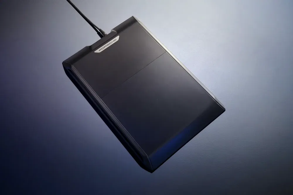 Lecteur de disquette noir avec câble connecté, design rétro minimaliste.
