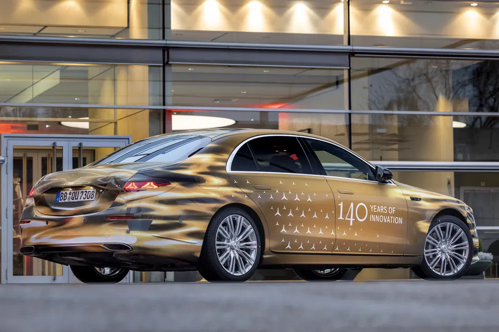 Mercedes-Benz avec design unique célébrant 140 ans d'innovation devant un bâtiment moderne.