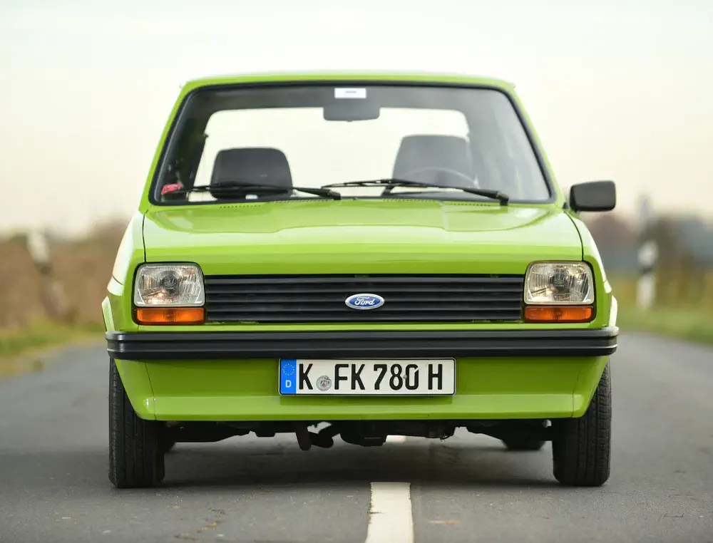 Ford Fiesta MK1 vert vif stationné sur une route, plaque allemande à l'avant.