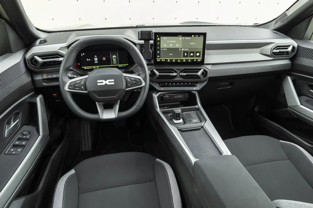 Intérieur moderne du Dacia Duster 2023 avec tableau de bord numérique et écran tactile.