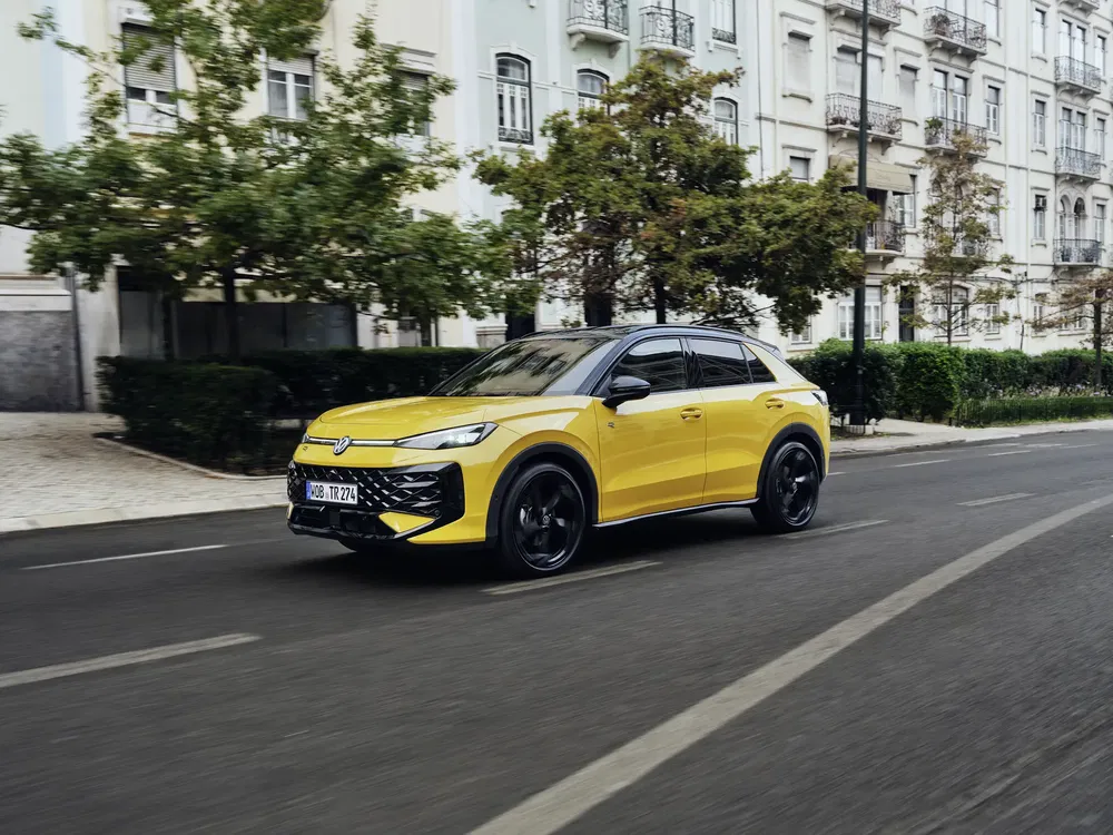 {"fr":"Volkswagen électrique jaune roulant en ville, design moderne, SUV compact, route bordée d'immeubles.","nl":"Gele elektrische Volkswagen rijdt in de stad, modern design, compacte SUV, straat met gebouwen."}