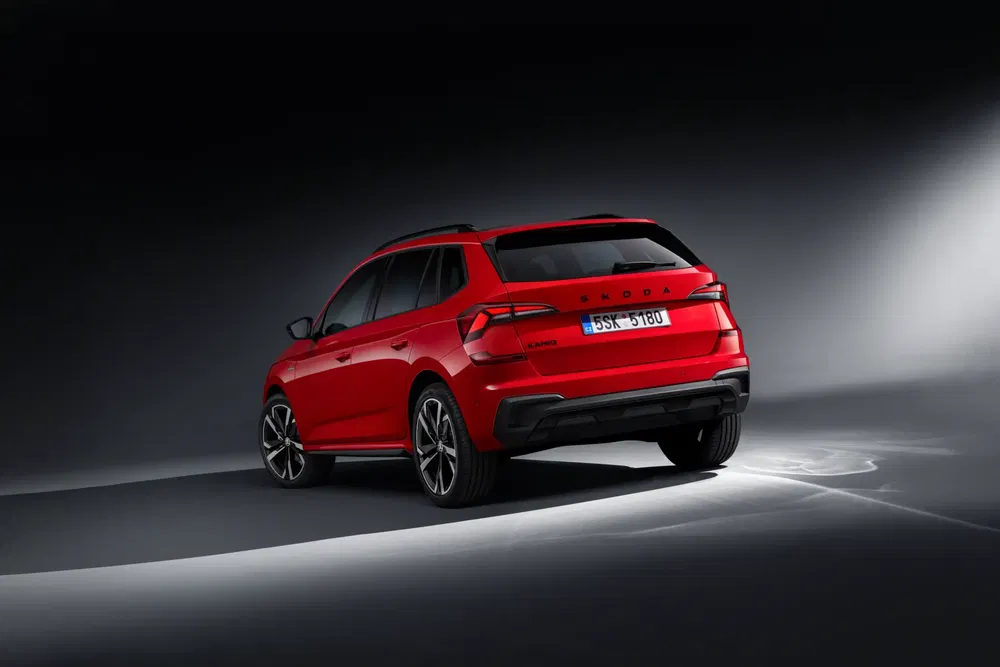 SUV Skoda Kamiq rouge, vue arrière, sur fond sombre.