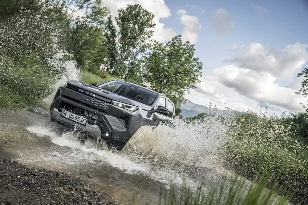 Toyota bZ4X traversant une rivière, démontrant ses capacités tout-terrain robustes.