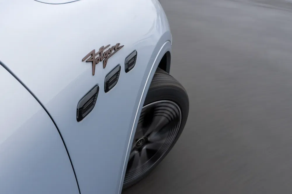 Vue rapprochée d'une Maserati blanche en mouvement, mettant en valeur les écopes latérales.
