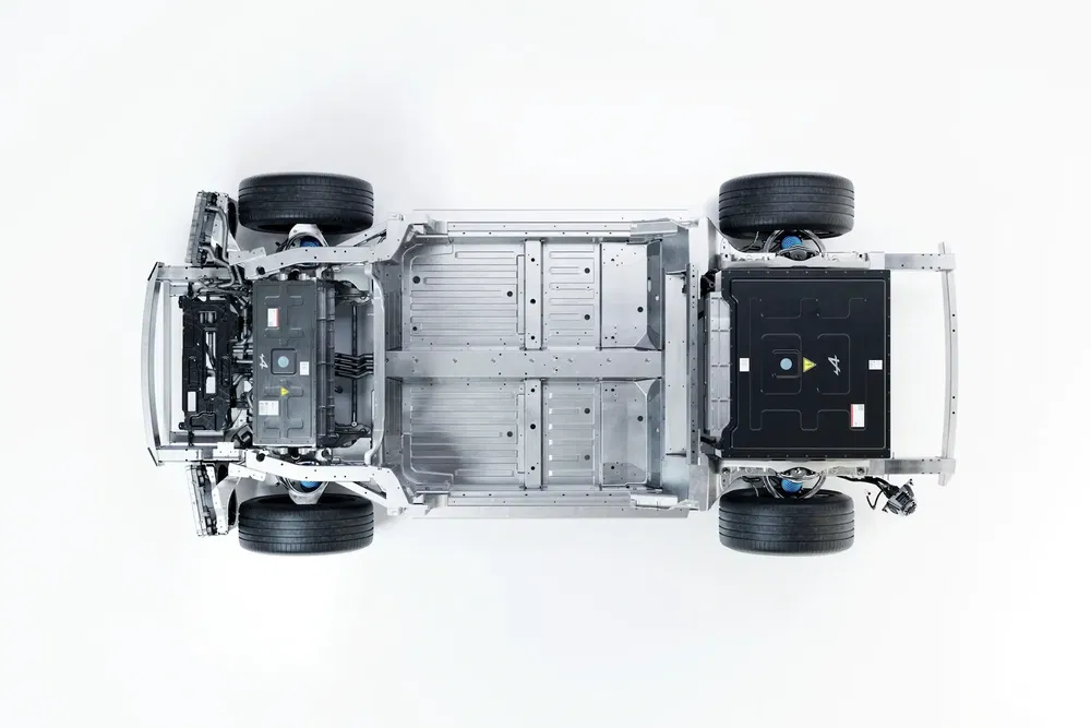 Châssis de voiture électrique avec batterie centrale et roues, vue de dessus.