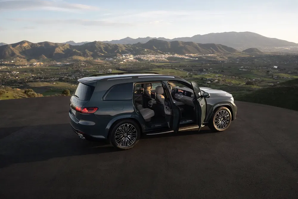 Mercedes GLS sur une route montagneuse avec portes ouvertes et vue panoramique.