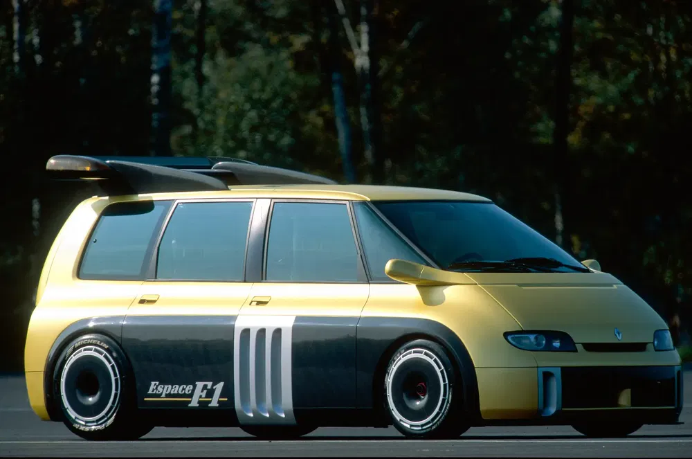 Renault Espace F1 jaune avec arrière sportif et prise d'air large sur un circuit.