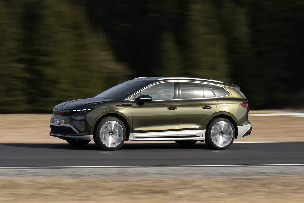 SUV Skoda Enyaq IV vert roulant sur route, profil latéral élégant et moderne.