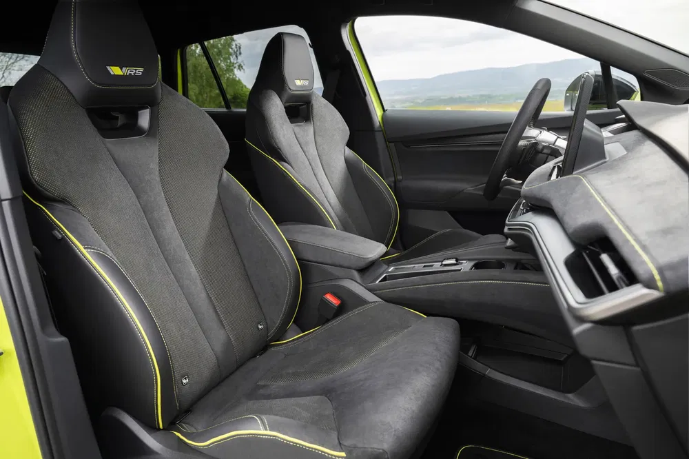 Interieur van de Skoda Octavia RS met zwarte sportstoelen en groene stiksels.