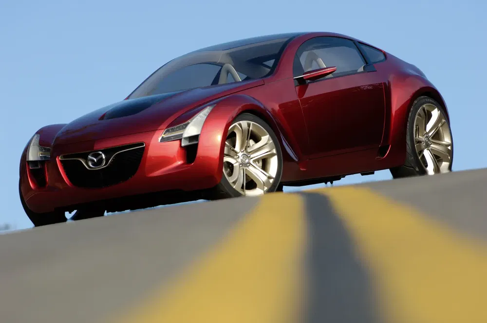 {"fr":"Mazda Kabura rouge brillant sur route en pente avec ciel bleu clair.","nl":"Felle rode Mazda Kabura op een heuvelachtige weg met een heldere blauwe lucht."}