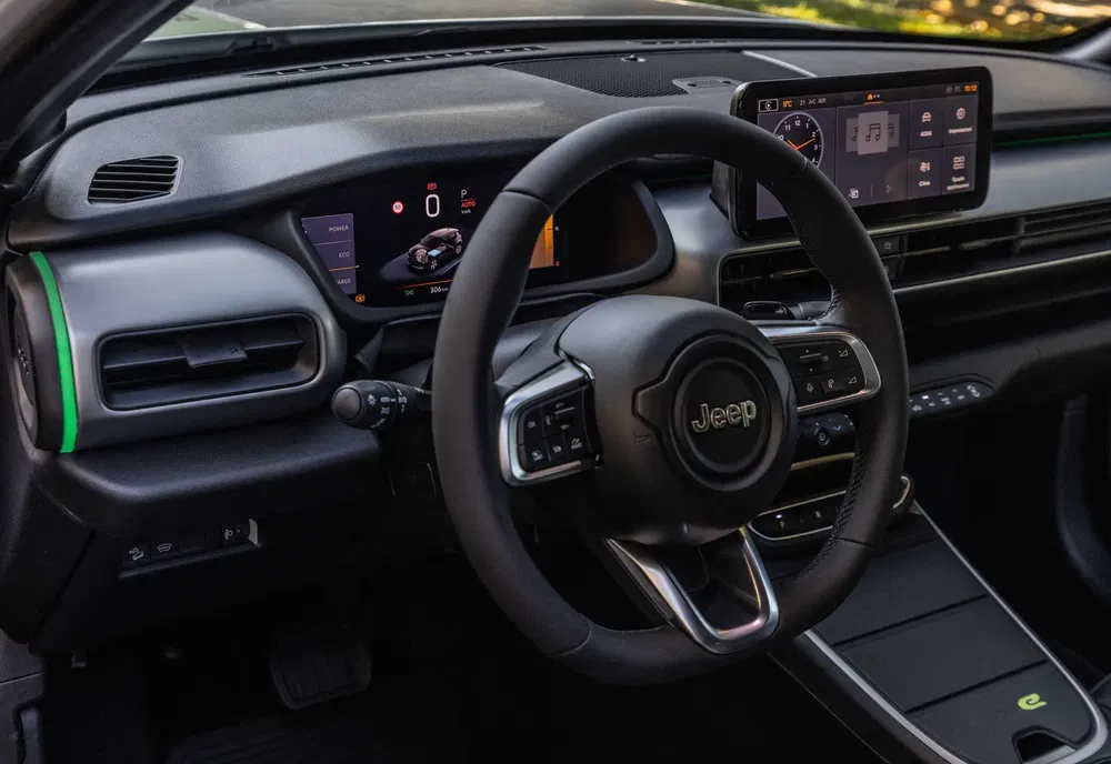 Intérieur d'une Jeep moderne avec tableau de bord numérique et volant élégant.