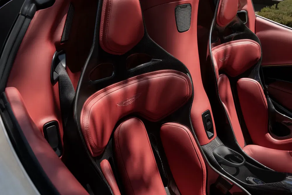 Intérieur de voiture Aston Martin avec sièges rouges en cuir et fibre de carbone.