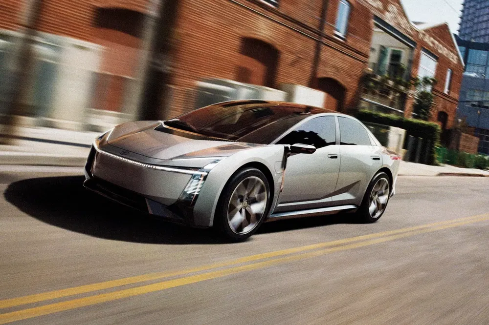La Cadillac Celestiq électrique roule dans une rue urbaine avec des bâtiments en briques.