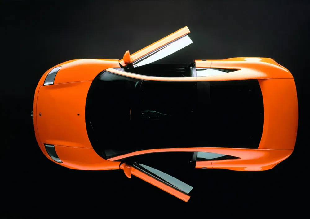 Oranje Lamborghini Gallardo van boven, vleugeldeuren open, studioverlichting.