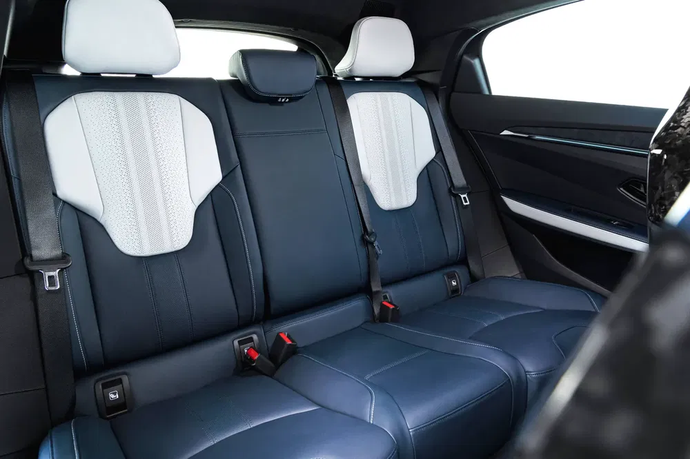 Intérieur arrière spacieux et élégant d'une voiture moderne avec sièges en cuir bleu et blanc.