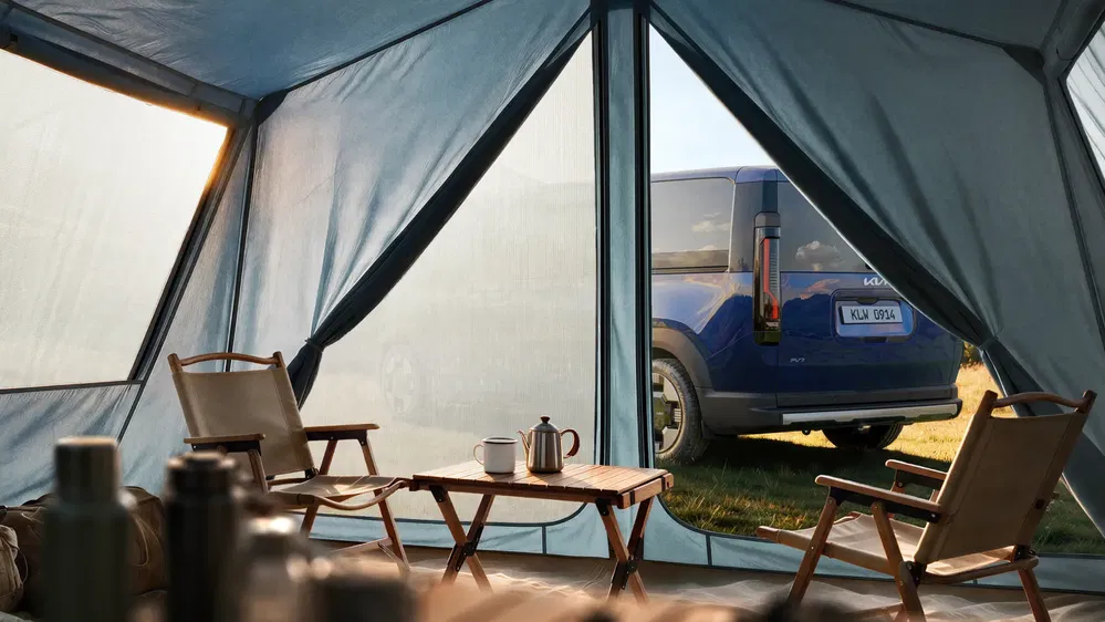 Vue d'une Hyundai Ioniq 7 depuis l'intérieur d'une tente de camping moderne.