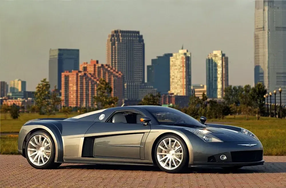 Zilveren Chrysler ME Four-Twelve conceptauto voor een moderne stedelijke skyline.