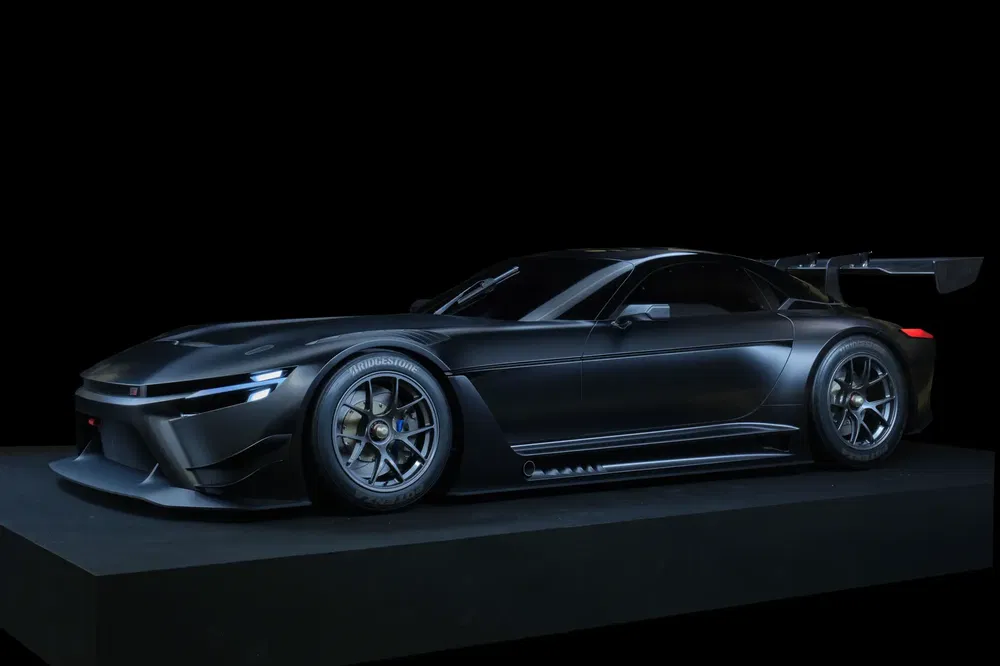 Zwarte Toyota GR GT3 met achtervleugel op zwarte achtergrond, agressief aerodynamisch design.