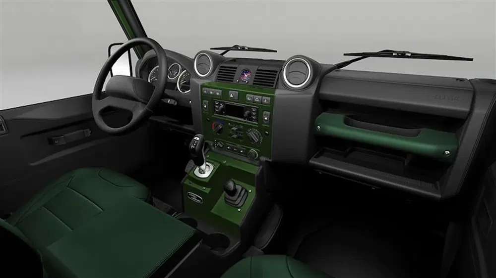 Intérieur du Land Rover Defender avec tableau de bord vert et sièges en cuir.