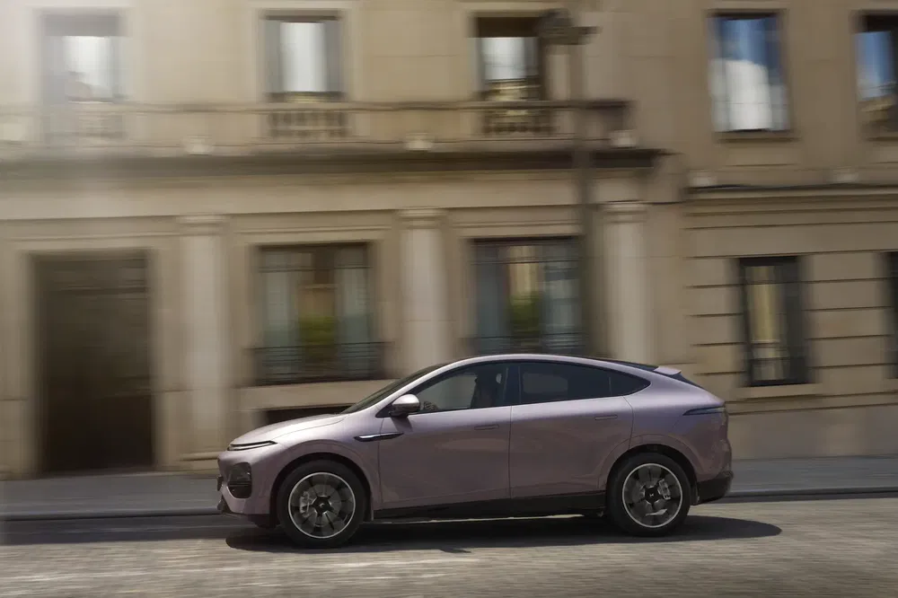{"fr":"SUV électrique moderne devant bâtiment urbain, design aérodynamique élégant et finition métallique.","nl":"Moderne elektrische SUV voor stedelijk gebouw, slank aerodynamisch ontwerp en metalen afwerking."}