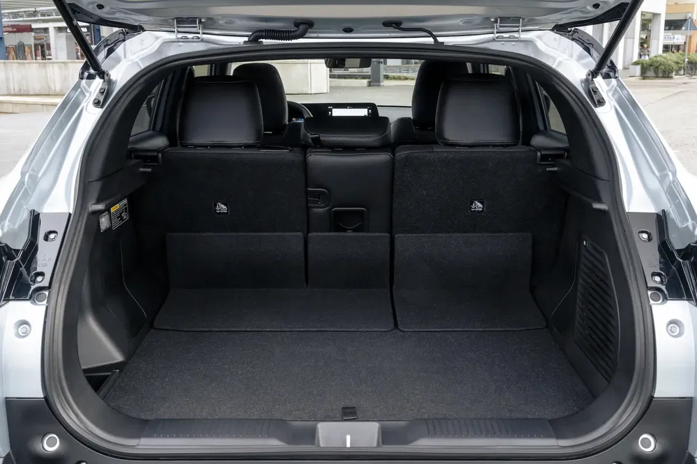 Coffre spacieux d'une Toyota Corolla Cross avec sièges arrière rabattables pour plus de chargement.