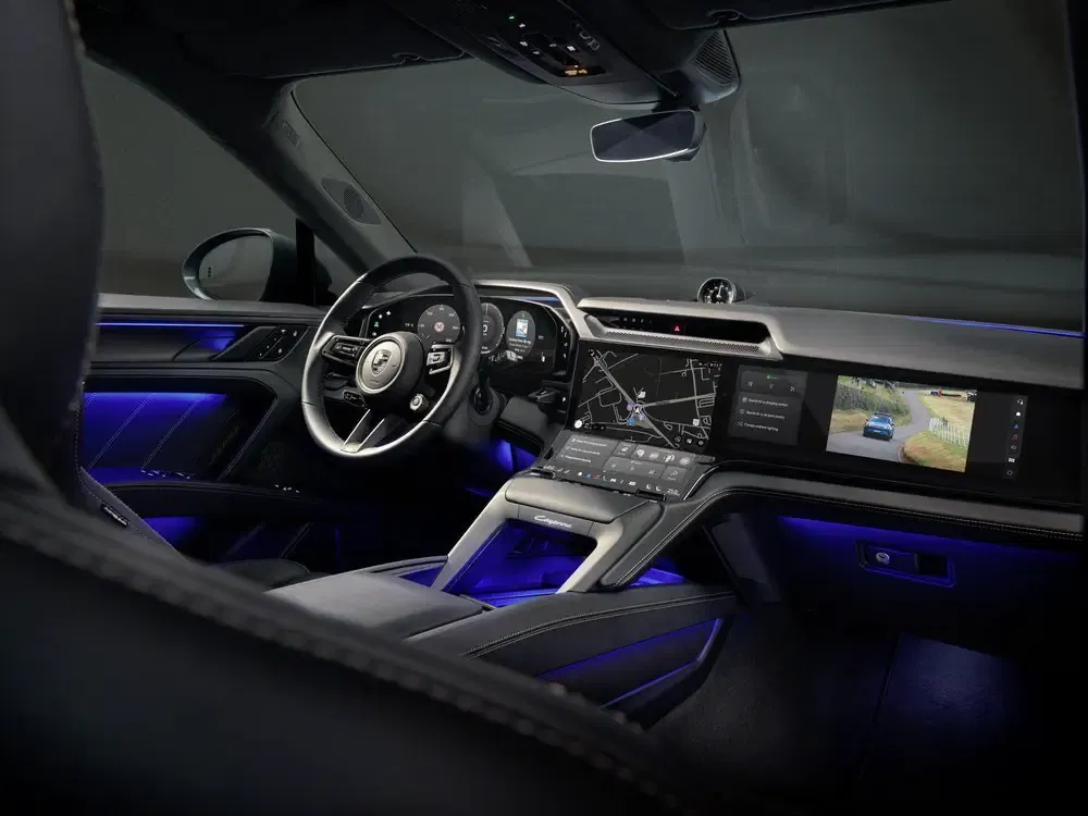Modern Porsche interieur met blauw LED-licht, touchscreen en digitaal dashboard.