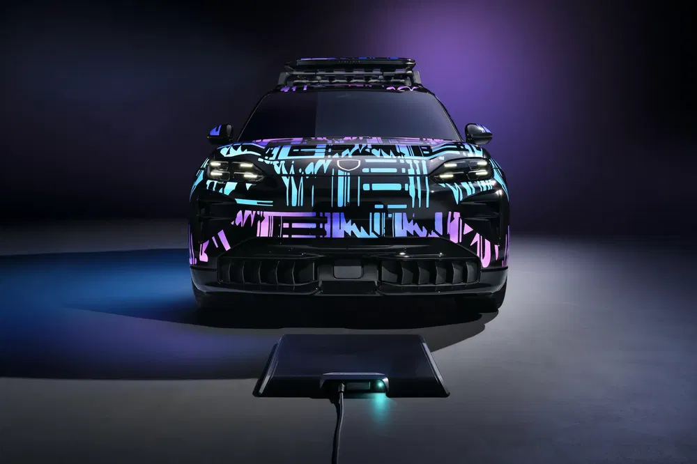 Porsche Macan électrique avec habillage lumineux vibrant, station de recharge sans fil avant.