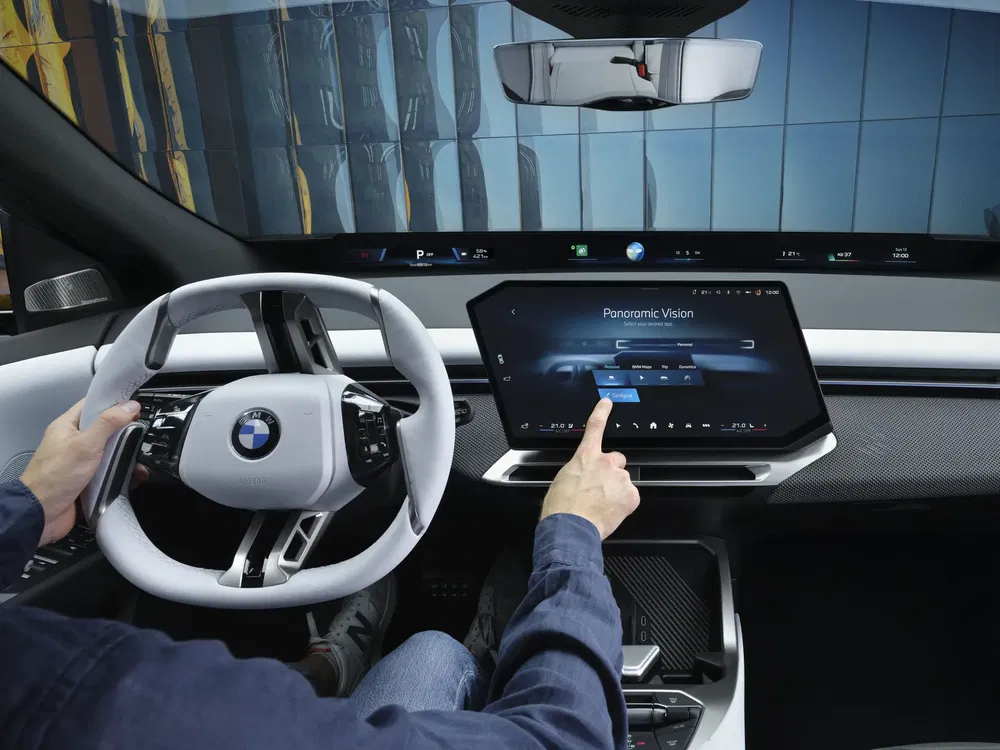 Moderne BMW-interieur met touchscreen en stijlvol stuurwiel.