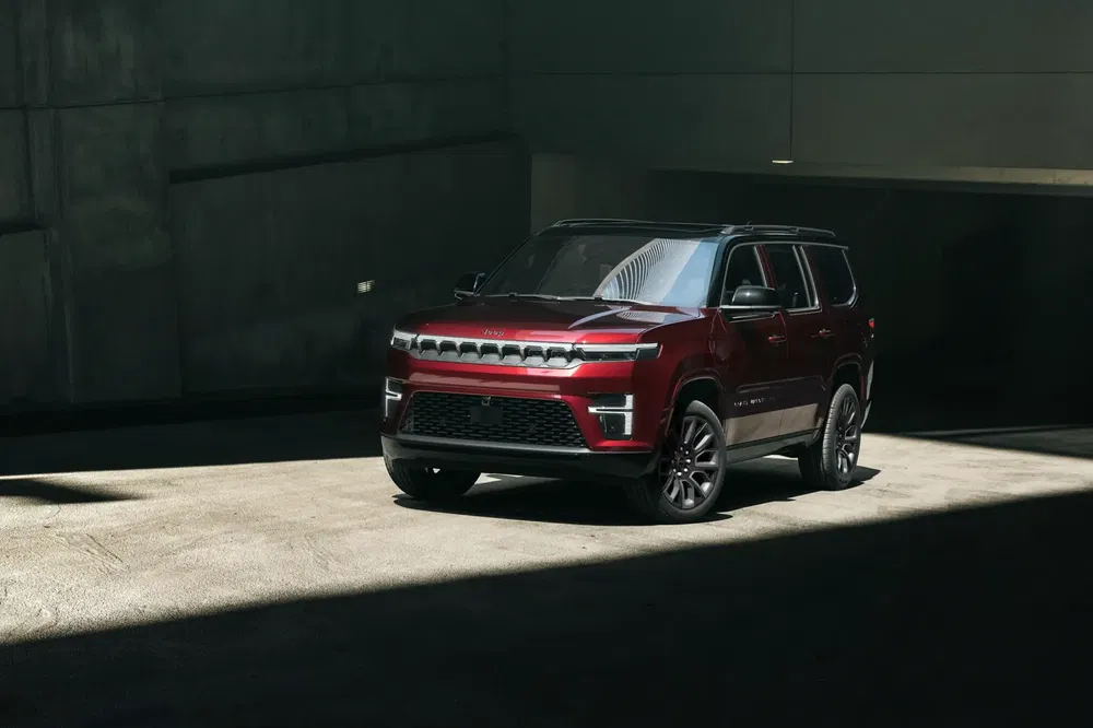 SUV rouge moderne dans un garage, éclairé par la lumière naturelle sur le côté.