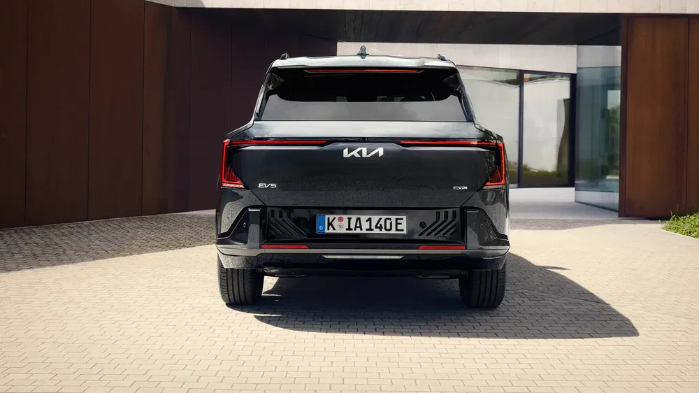 Vue arrière du Kia EV9 2023 montrant des feux LED modernes dans une allée.