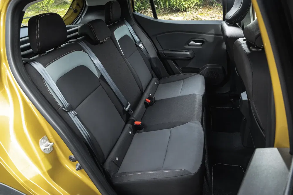 Intérieur arrière de la Dacia Sandero Stepway avec sièges en tissu noir et garnitures contrastées.