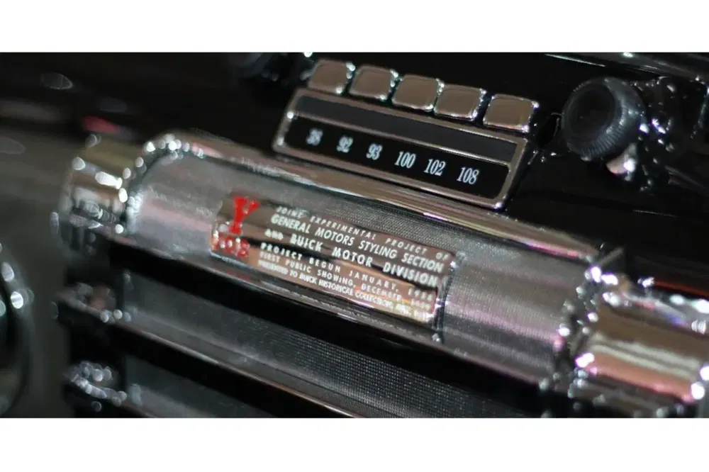 Radio vintage Buick, écran fréquence métal chromé et boutons noirs, style rétro.