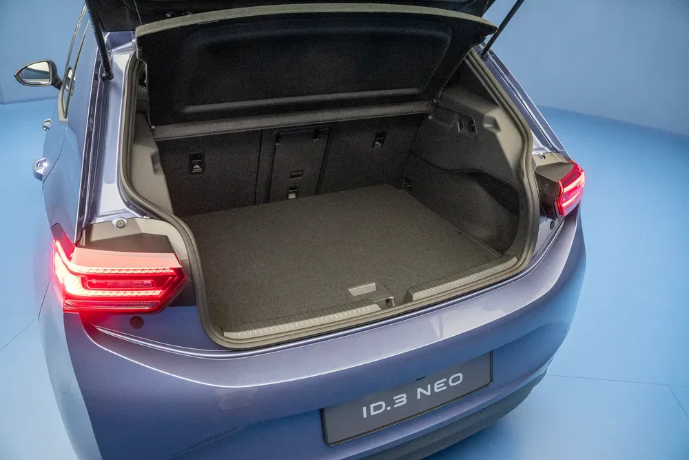 Coffre spacieux de la Volkswagen ID.3 NEO avec sièges rabattables, vue arrière éclairée.