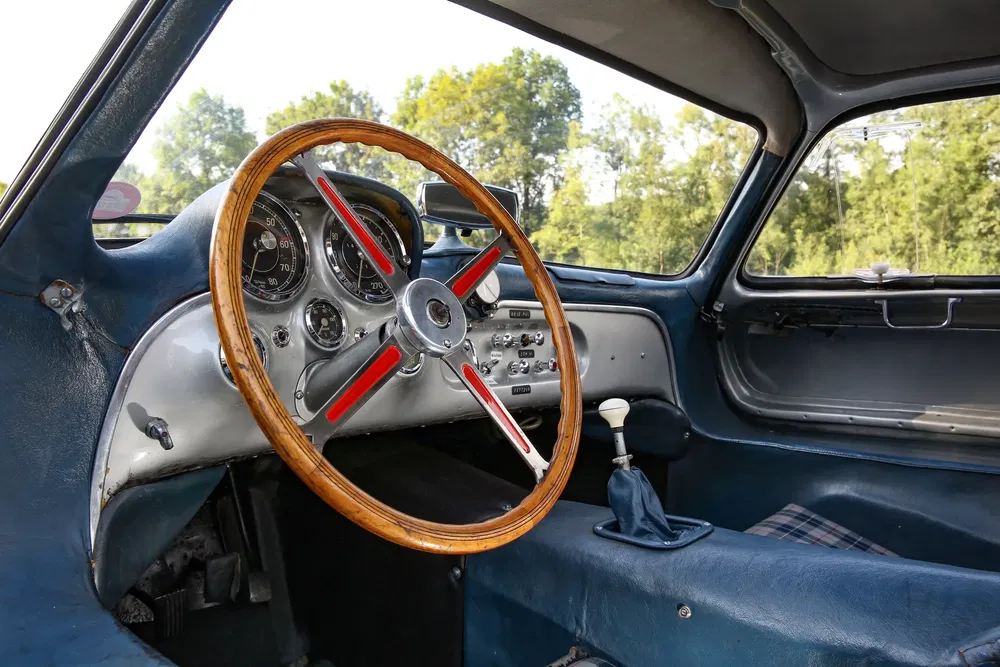 Intérieur vintage de la Mercedes-Benz 300 SL avec volant bois et tableau de bord classique.