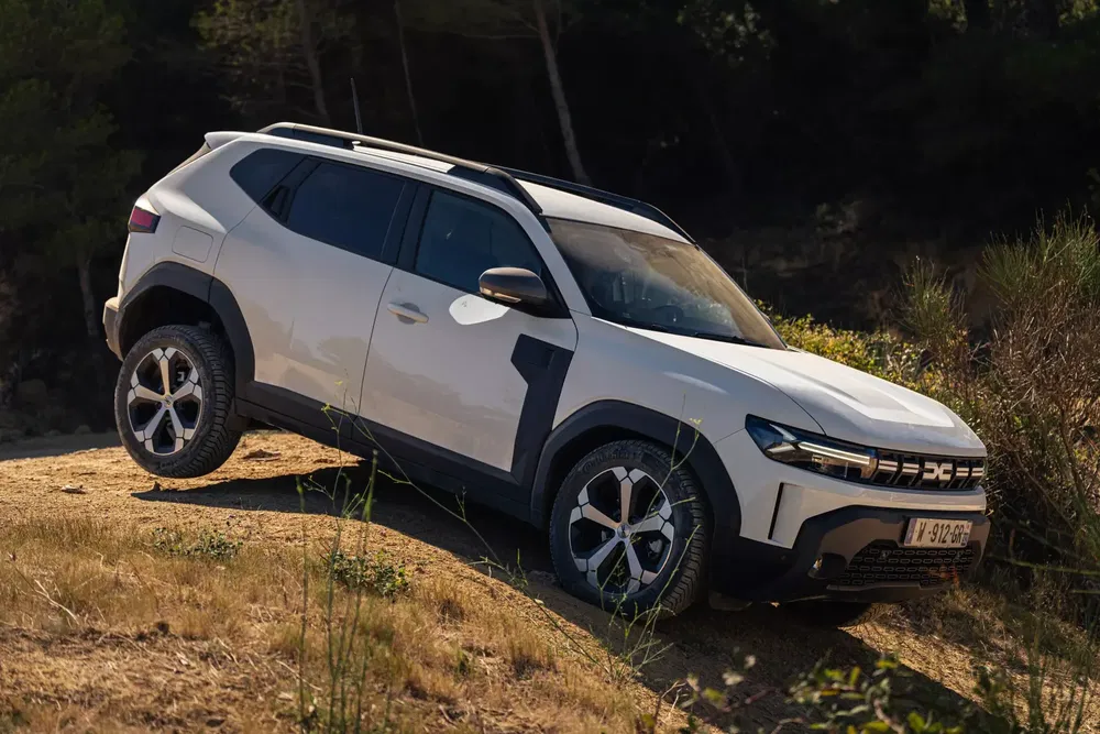 SUV Dacia blanc sur terrain accidenté, expérimentant la puissance tout-terrain des véhicules modernes.