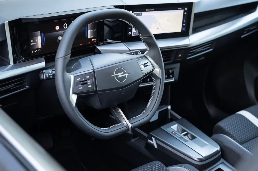 Intérieur moderne d'une Opel avec volant et tableau de bord numérique avancé.