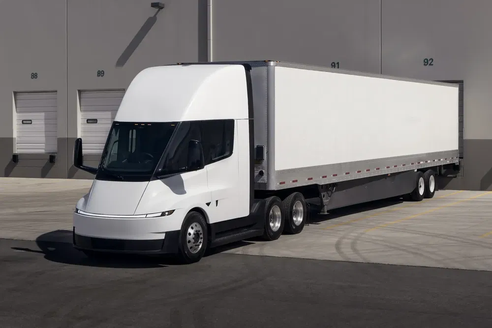 {"fr":"Camion électrique Tesla Semi garé devant entrepôt industriel moderne.","nl":"Elektrische vrachtwagen Tesla Semi geparkeerd voor modern industrieel magazijn."}