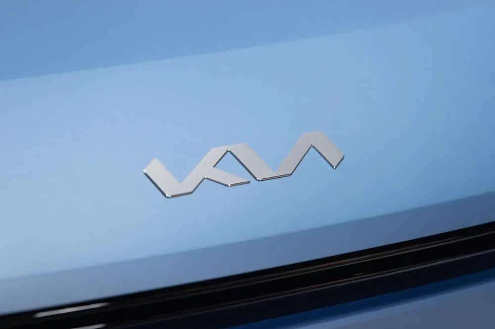 {"fr":"Logo Kia argenté sur fond bleu clair de voiture moderne.","nl":"Zilveren Kia-logo op lichtblauwe achtergrond van moderne auto."}