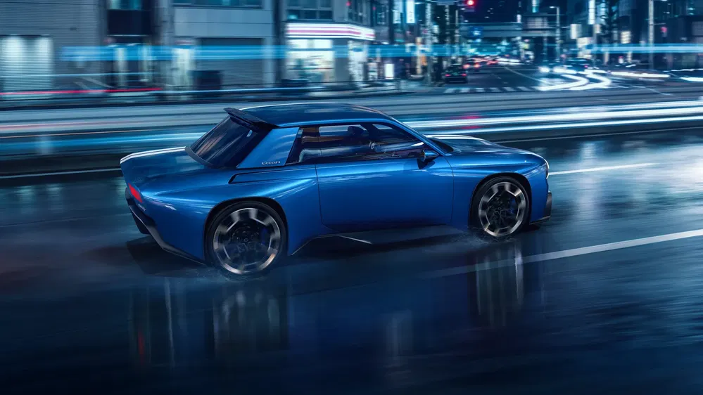 Concept Toyota Kikai sur route urbaine humide la nuit, design futuriste élégant.