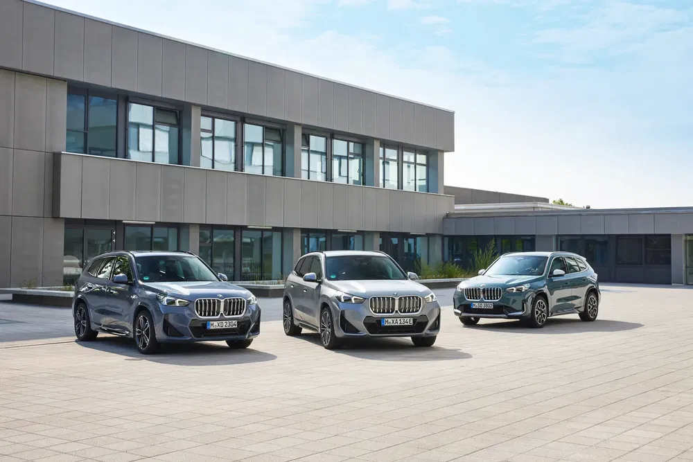 Drie BMW X1 geparkeerd voor een modern gebouw, strak en stijlvol ontwerp.