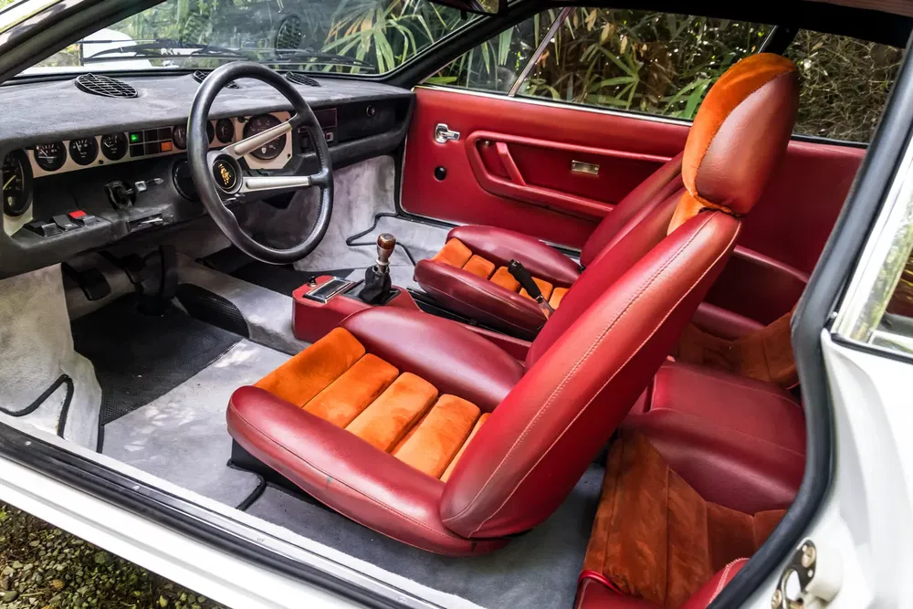 {"fr":"Intérieur de voiture classique avec sièges en cuir rouge et tableau de bord vintage.","nl":"Klassiek autointerieur met rode lederen stoelen en vintage dashboard."}