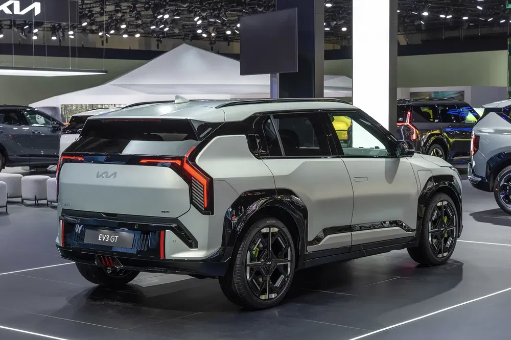 Kia EV3 GT dans un salon automobile, à l'arrière avec design moderne et feux LED distinctifs.