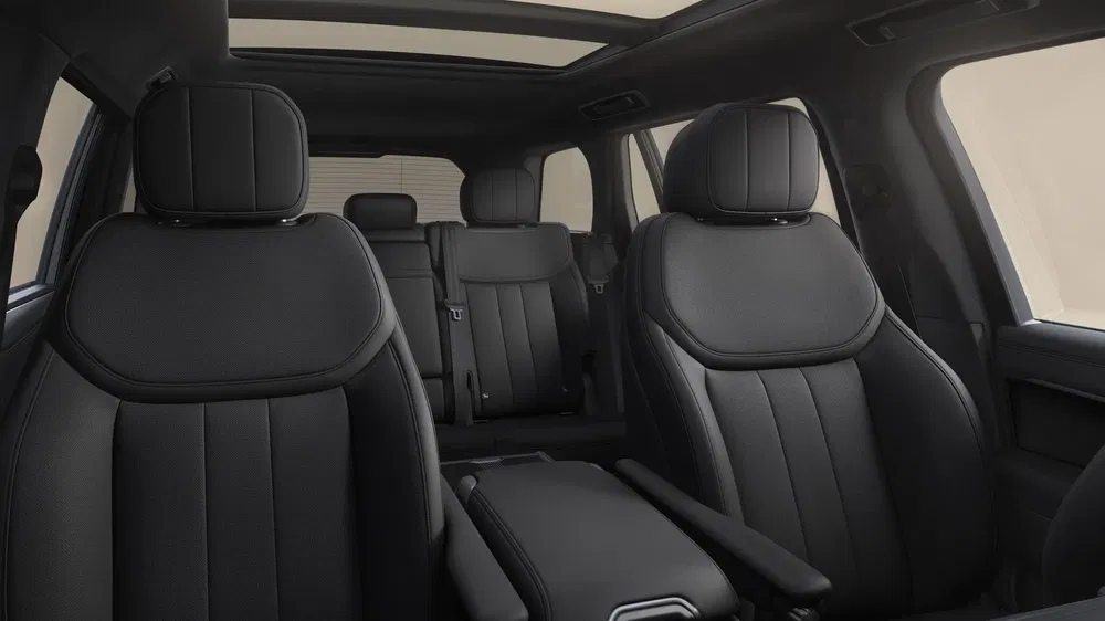 Intérieur luxueux d'un SUV moderne avec sièges en cuir noir et toit ouvrant panoramique.